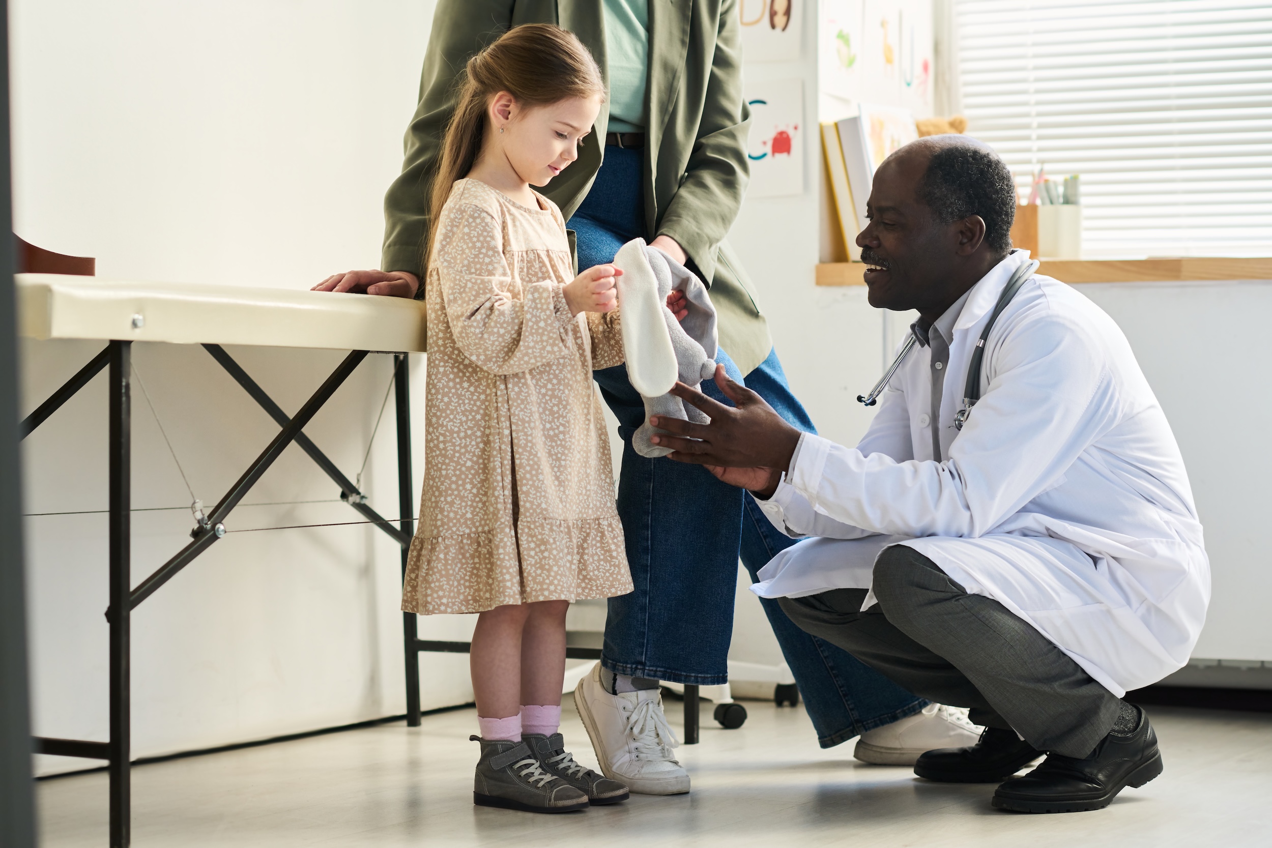 Young girl with mom seeing a doctor for osteosarcoma